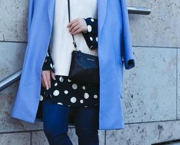 Outfit mit Cosmoparis Tajou Tasche, blauem Mantel und Pünktchenkleid