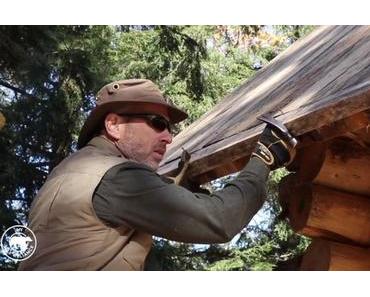 Handwerker baut sich mit einfachen Werkzeugen eine Holzhütte